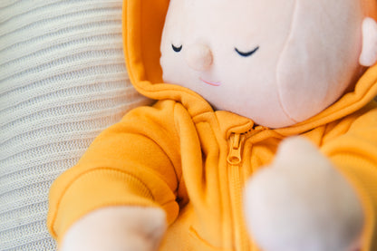 Plush toy in a yellow outfit with a neutral background